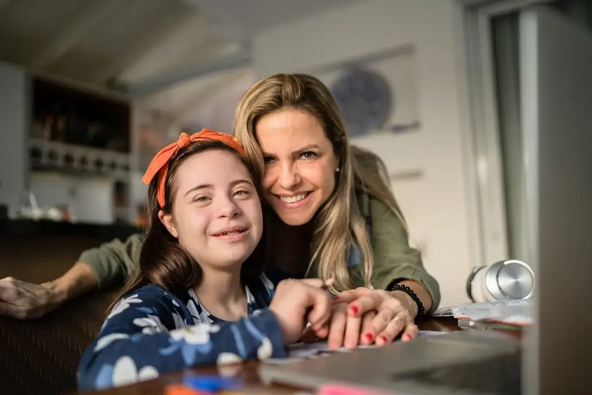 Madre e figlia sorridono, la bambina con sindrome di Down, un esempio di come l'invalidit&agrave; al 30 per cento non limiti la gioia.
