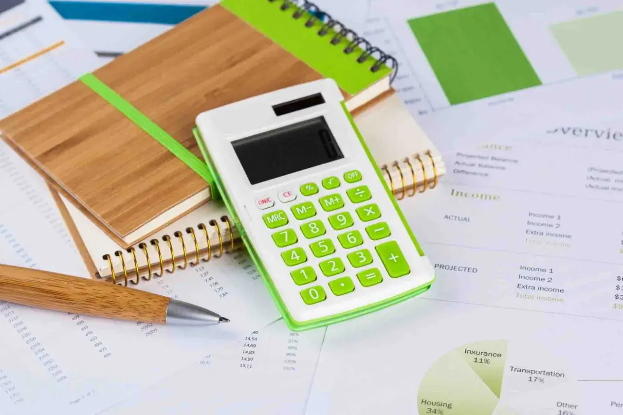 Calculadora y cuaderno sobre documentos financieros. Planificando c&oacute;mo refinanciar hipoteca para optimizar gastos.