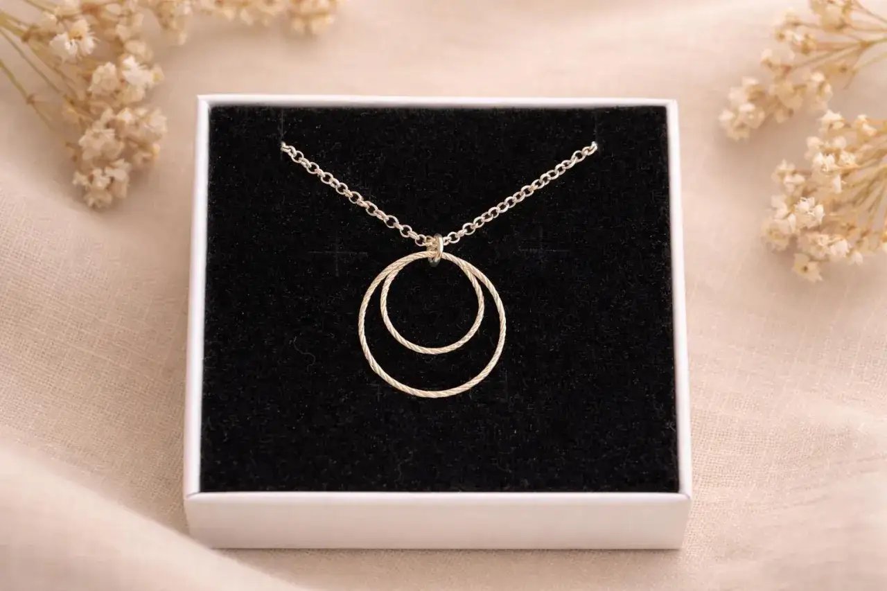 Collana con due anelli intrecciati, simbolo di legame eterno e amore.