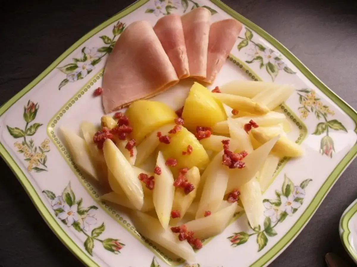 Spargel mit Kartoffeln und Schinken, bestreut mit Speckwürfeln. Ein Gericht, das den puren Spargel Geschmack zur Geltung bringt.