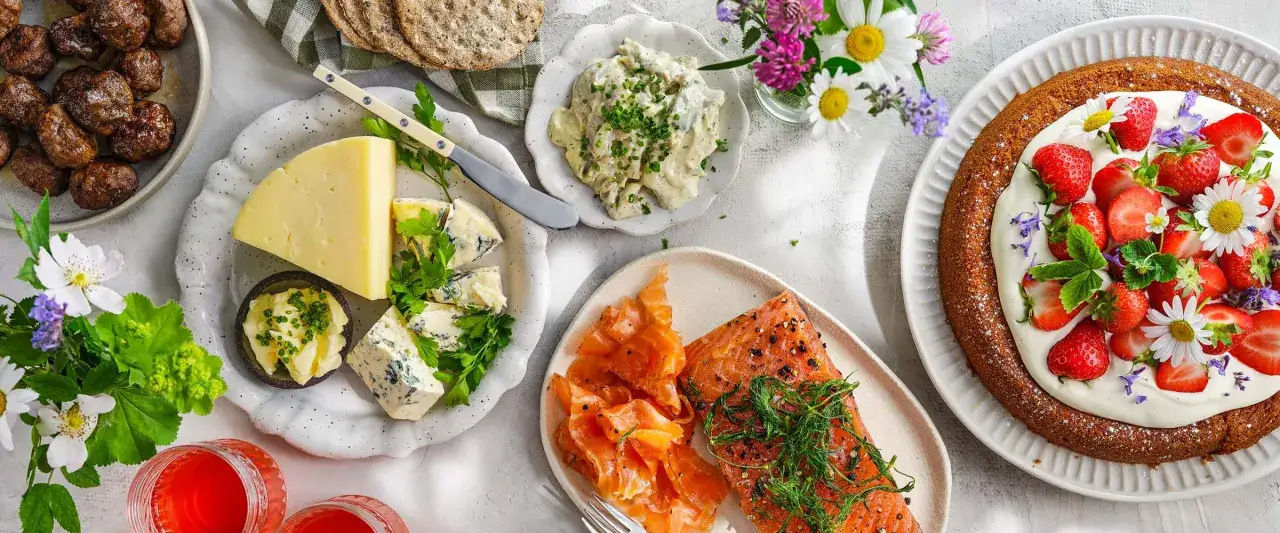 En härlig midsommarmåltid med lax, köttbullar, ost och en jordgubbstårta. En annorlunda midsommarmat som passar alla smaker.