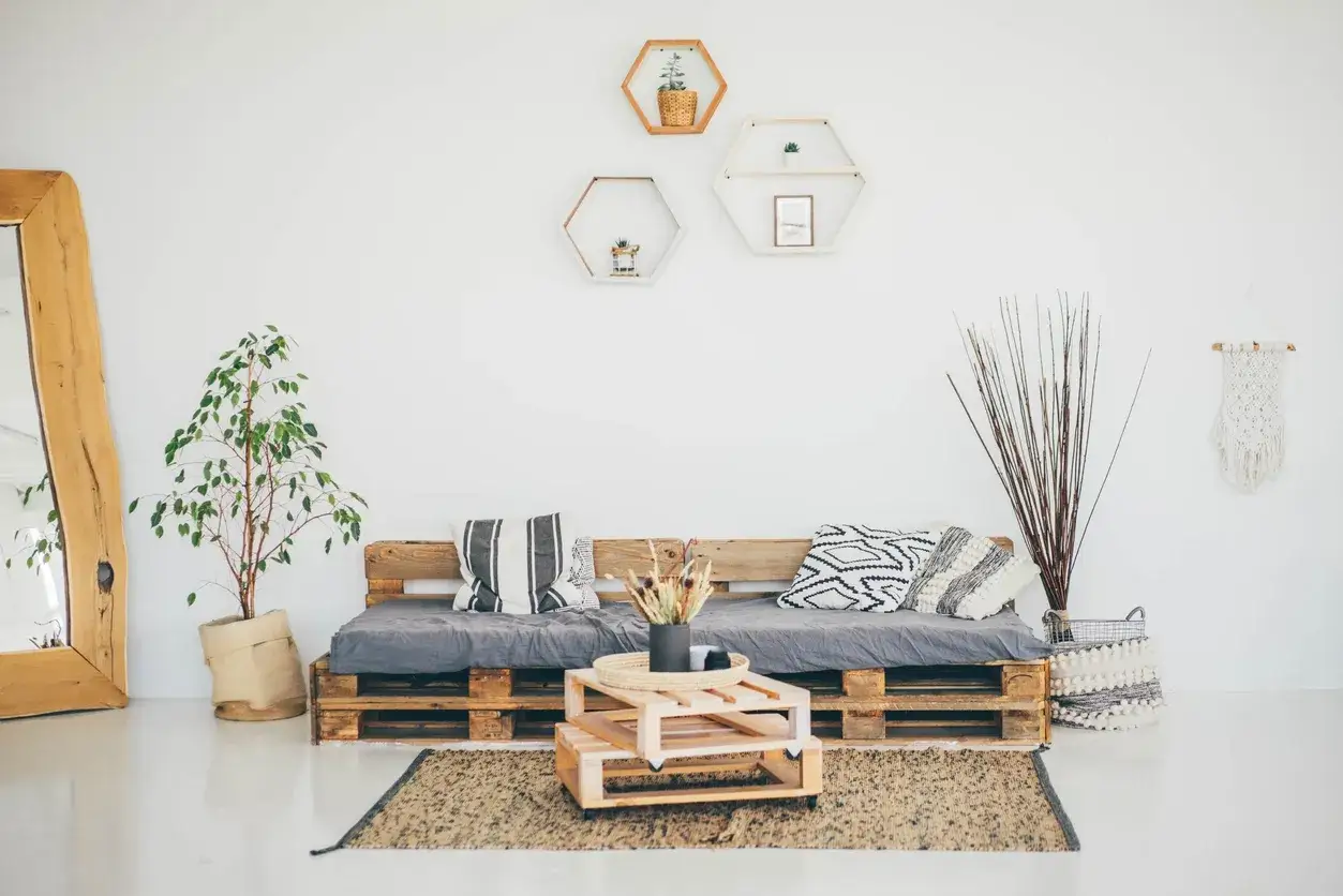 Ein gemütliches Palettensofa bauen: DIY-Möbel mit Kissen und Pflanzen für ein entspanntes Wohnzimmer.