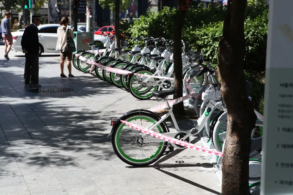 Reihe von weißen Leihrädern mit grünen Felgen, bereit für das sharing city Seoul.