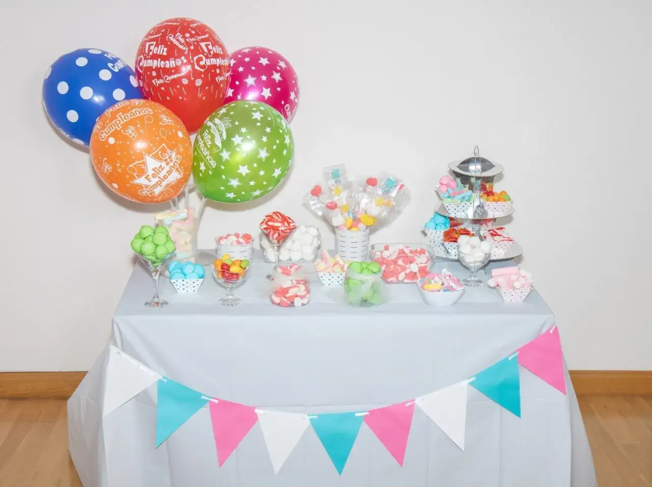 Mesa llena de chuches y globos para una fiesta. &iexcl;Ideal para aprender como hacer bolas de chuches!