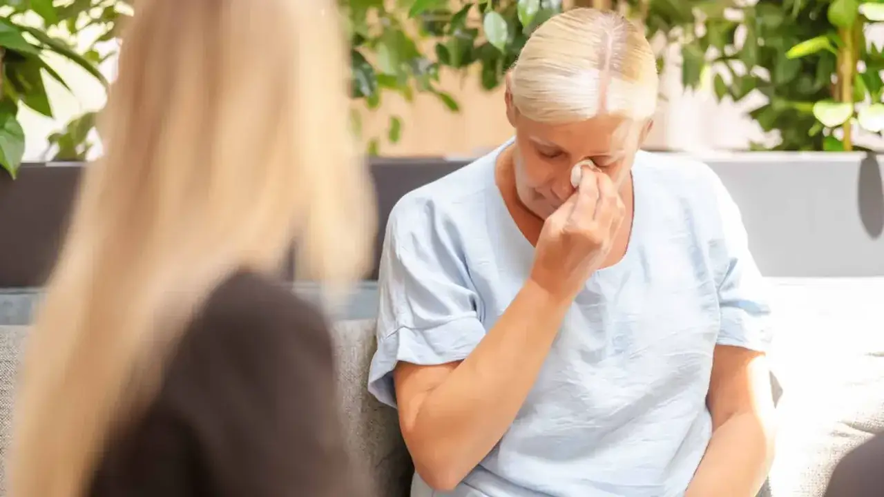 Eine Frau wischt sich mit einem Taschentuch die Augen. Sie scheint emotional aufgew&uuml;hlt zu sein, aber in diesem Moment des Loslassens findet sie zu **im reinen sein**.