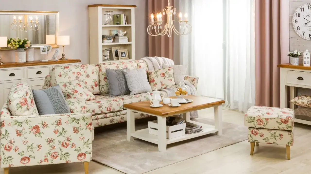 Przytulny styl shabby chic salon z kwiecistą sofą, drewnianym stolikiem kawowym i pastelowymi zasłonami.