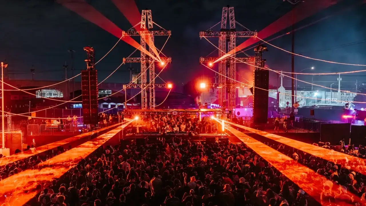 Un'enorme folla balla sotto fasci di luce rossa in uno dei festival techno pi&ugrave; famosi. L'energia &egrave; palpabile.