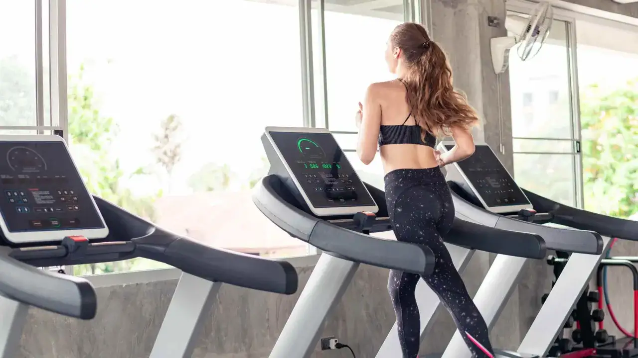Mujer corriendo en cinta. ¿Qué es mejor bici estática o cinta de correr? La cinta ofrece un entrenamiento cardiovascular completo.