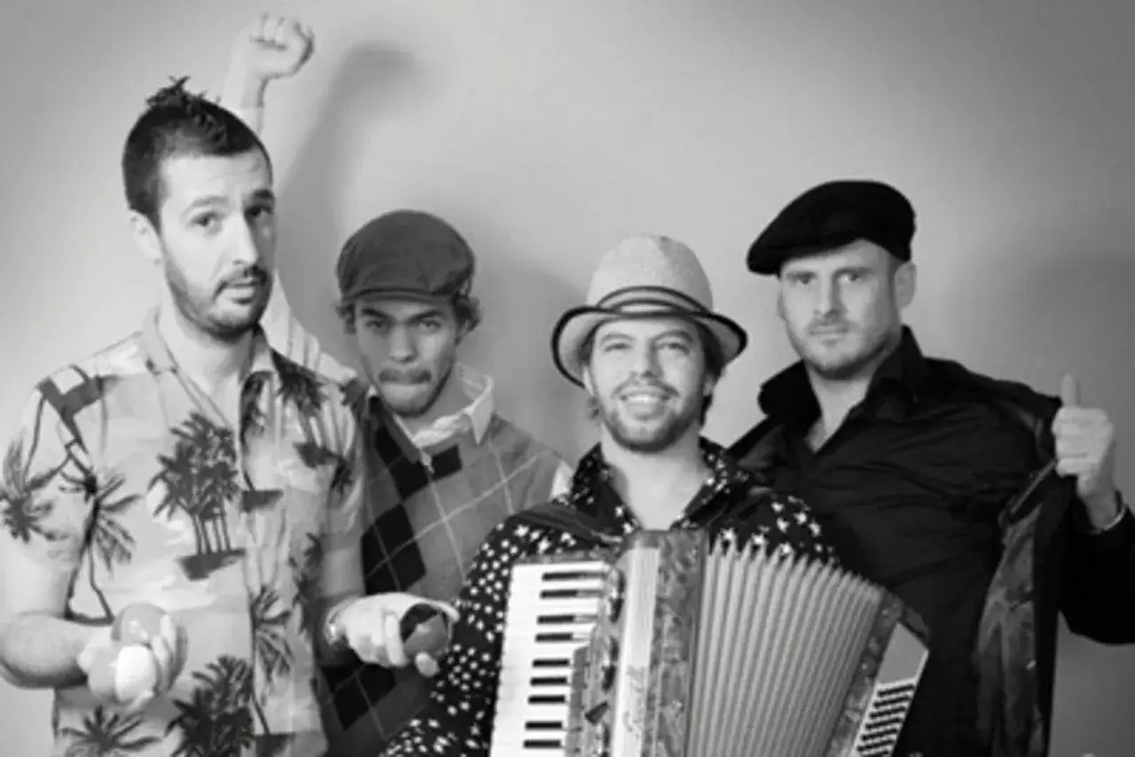 Le groupe java, avec son accordéoniste au centre, pose joyeusement. L'un des musiciens lève le poing, un autre fait un clin d'œil.