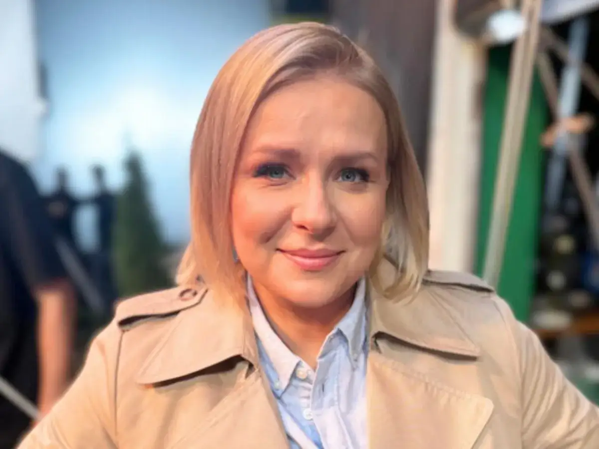 Uśmiechnięta blondynka w beżowym płaszczu. Ciekawe, ile lat ma Aneta Zając, bo wygląda kwitnąco!