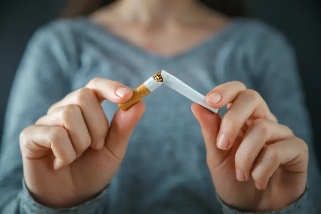 H&auml;nde brechen Zigarette, ein Zeichen f&uuml;r den Rauchstopp. Alternativen wie der Nicorette Inhalator helfen dabei.