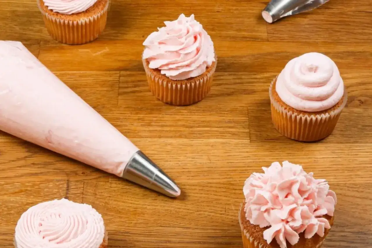 F&auml;rgglada cupcakes med rosa frosting, redo att dekoreras. Perfekt f&ouml;r att baka med Philadelphia!