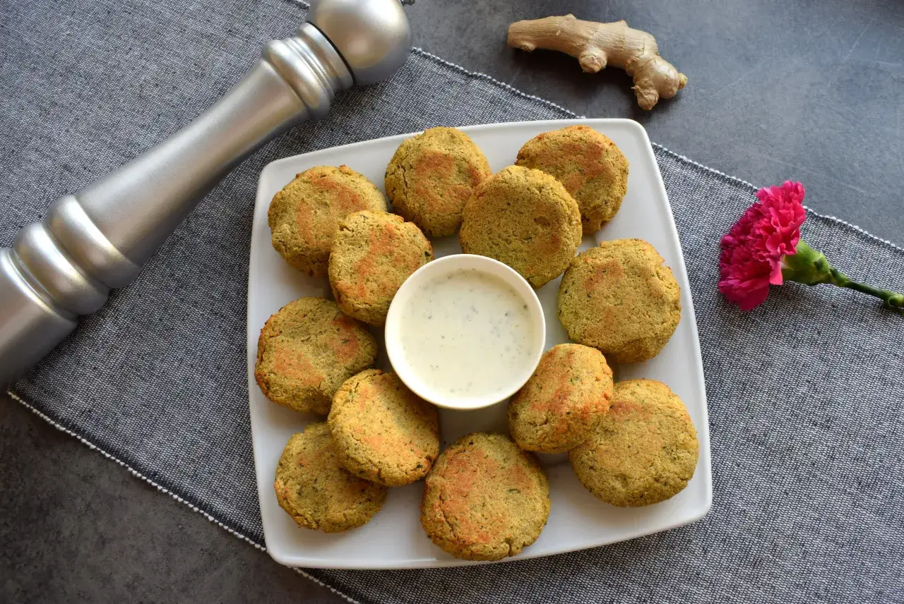 Pyszny falafel przepis na talerzu, z sosem i ozdobiony kwiatkiem.