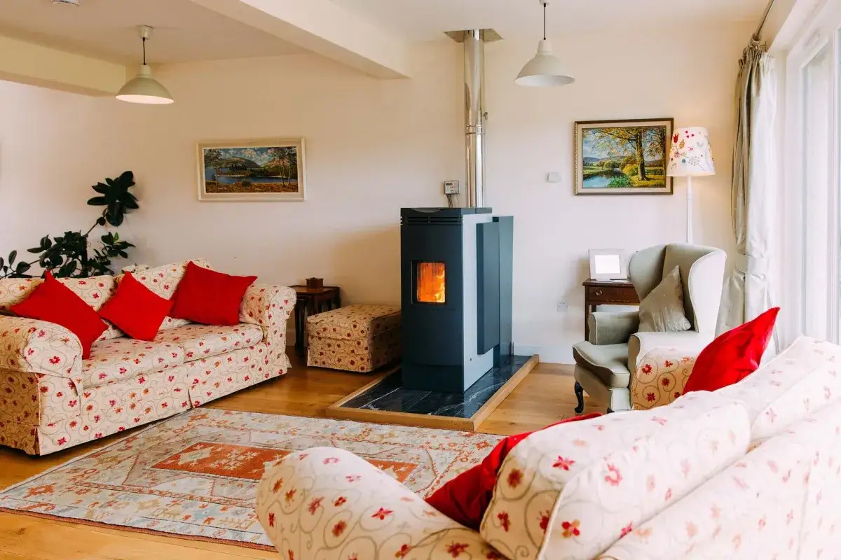Stufa a pellet moderna, un modo efficace per riscaldare la casa senza termosifoni, in un accogliente soggiorno con divani e tappeto.