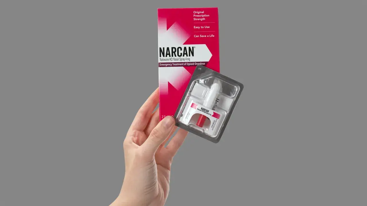 Dłoń trzyma opakowanie z lekiem nalokson, który może uratować życie w nagłych przypadkach przedawkowania opioidów.