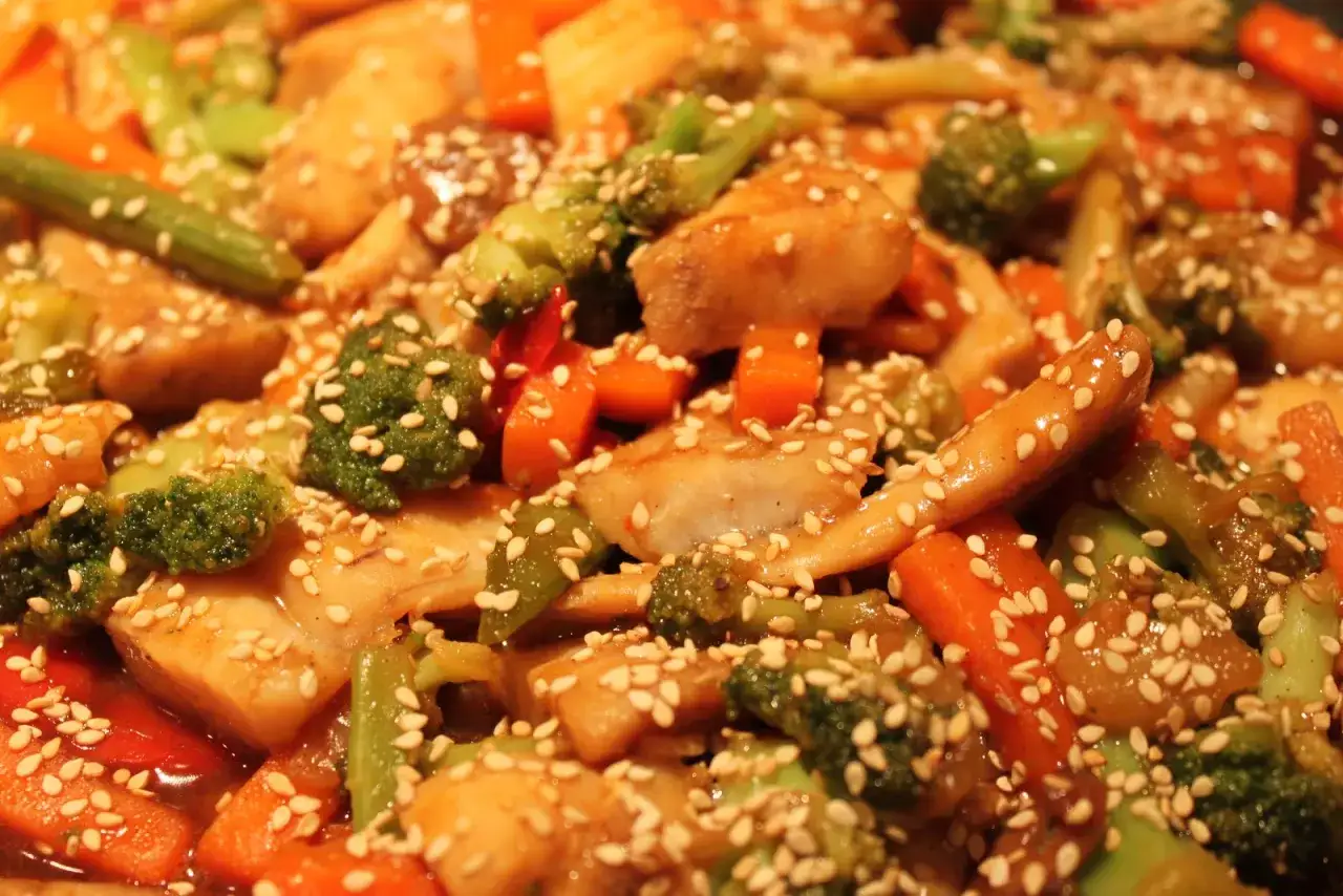 Un délicieux wok de poisson aux légumes croquants, brocolis, carottes et poivrons, le tout saupoudré de graines de sésame.