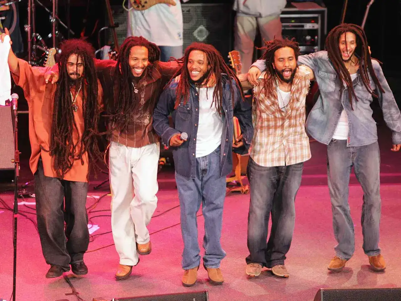 Pięciu mężczyzn z dredami, przypominających bob marley dzieci, na scenie.