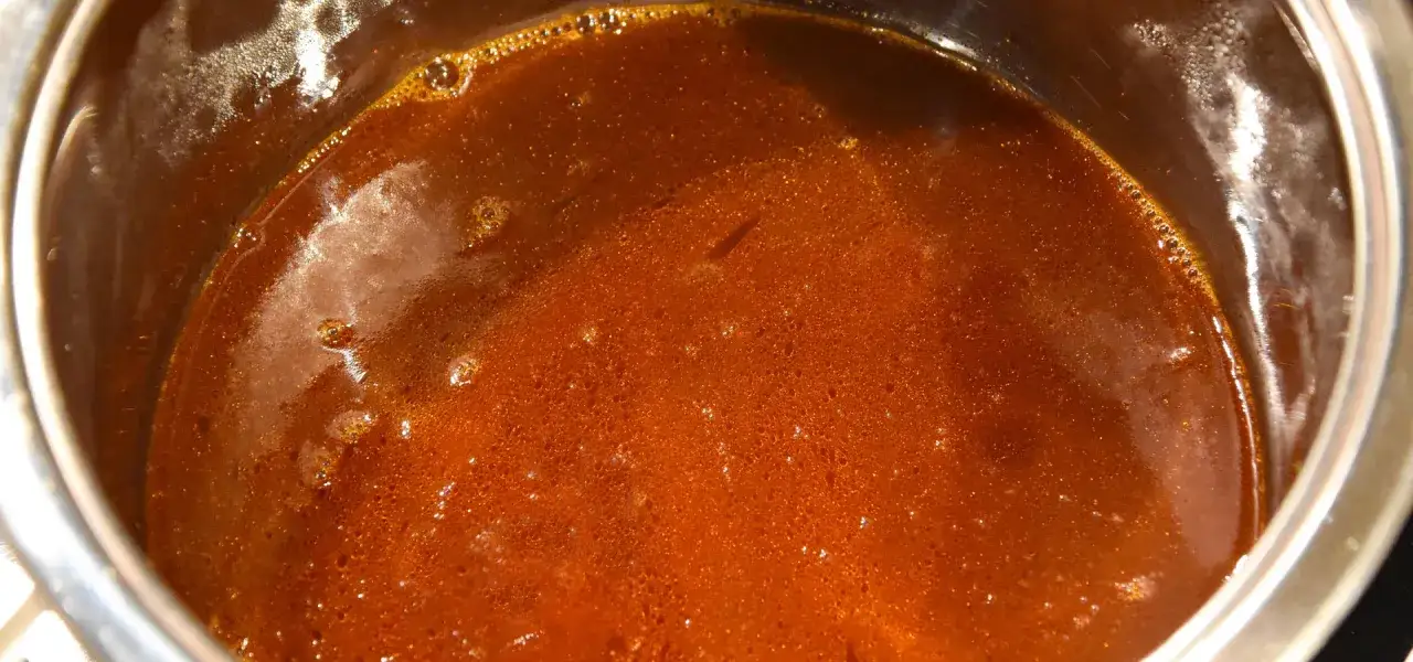Eine köstliche, dunkle Grundsauce blubbert in einem Topf. Sie duftet nach herzhaften Aromen und ist bereit, Gerichte zu verfeinern.