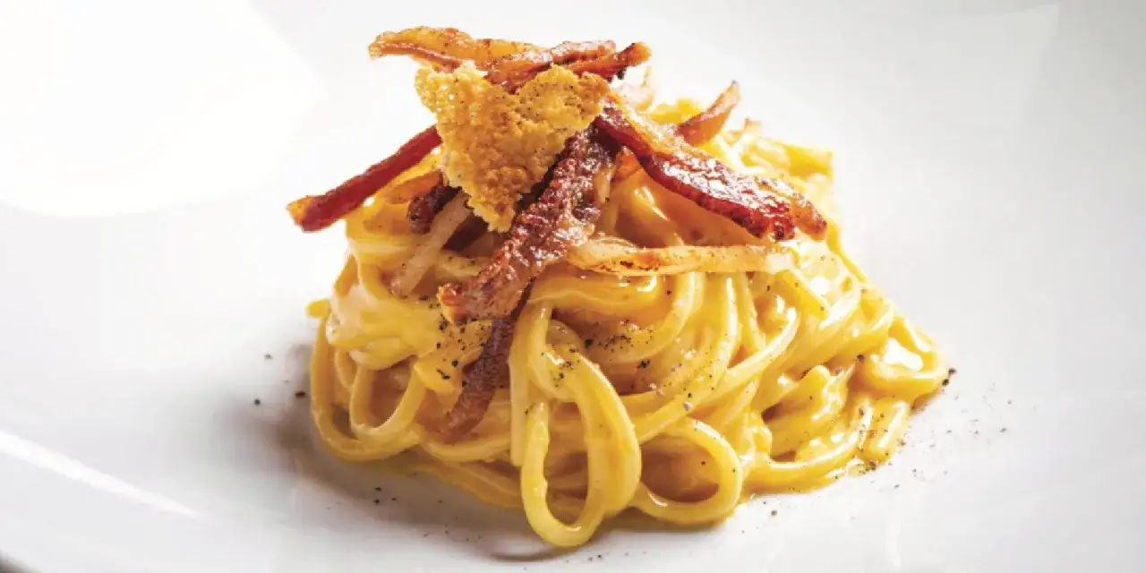Un piatto di spaghetti cremosi, conditi con guanciale croccante e pecorino, un classico della ricetta della carbonara.