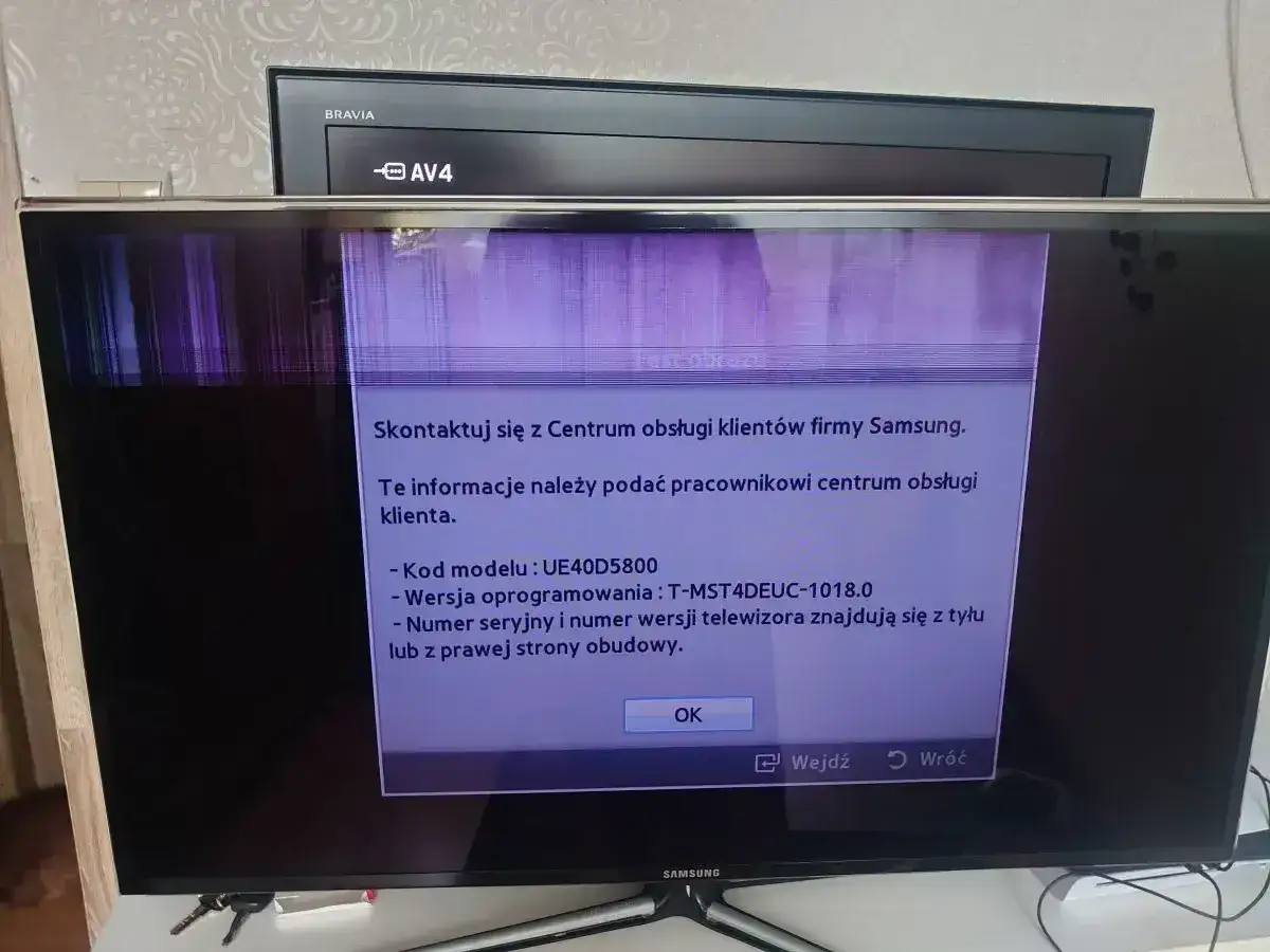 Uszkodzony ekran telewizora Samsung, widoczny komunikat o kontakcie z serwisem. Prawdopodobnie czeka go wymiana matrycy w telewizorze.