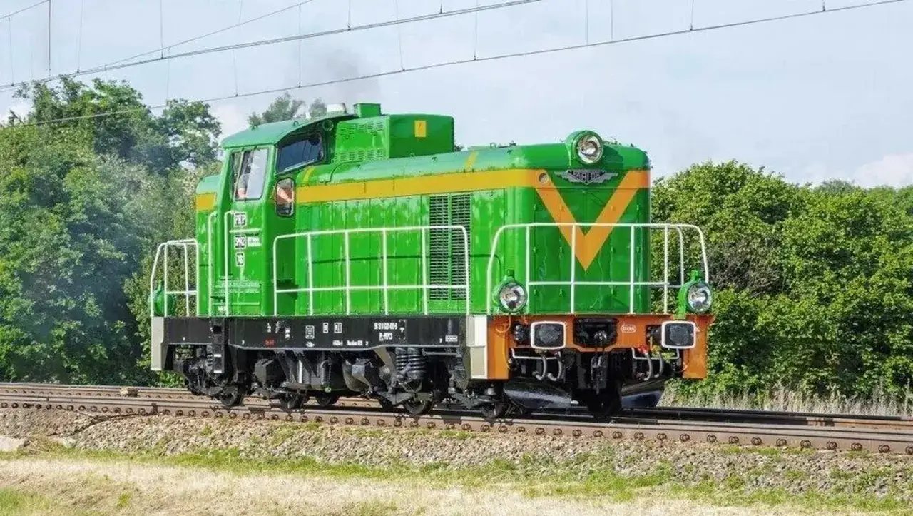 Zielona lokomotywa **Fablok 6D** z żółtym pasem i literami PKP na tle zieleni.