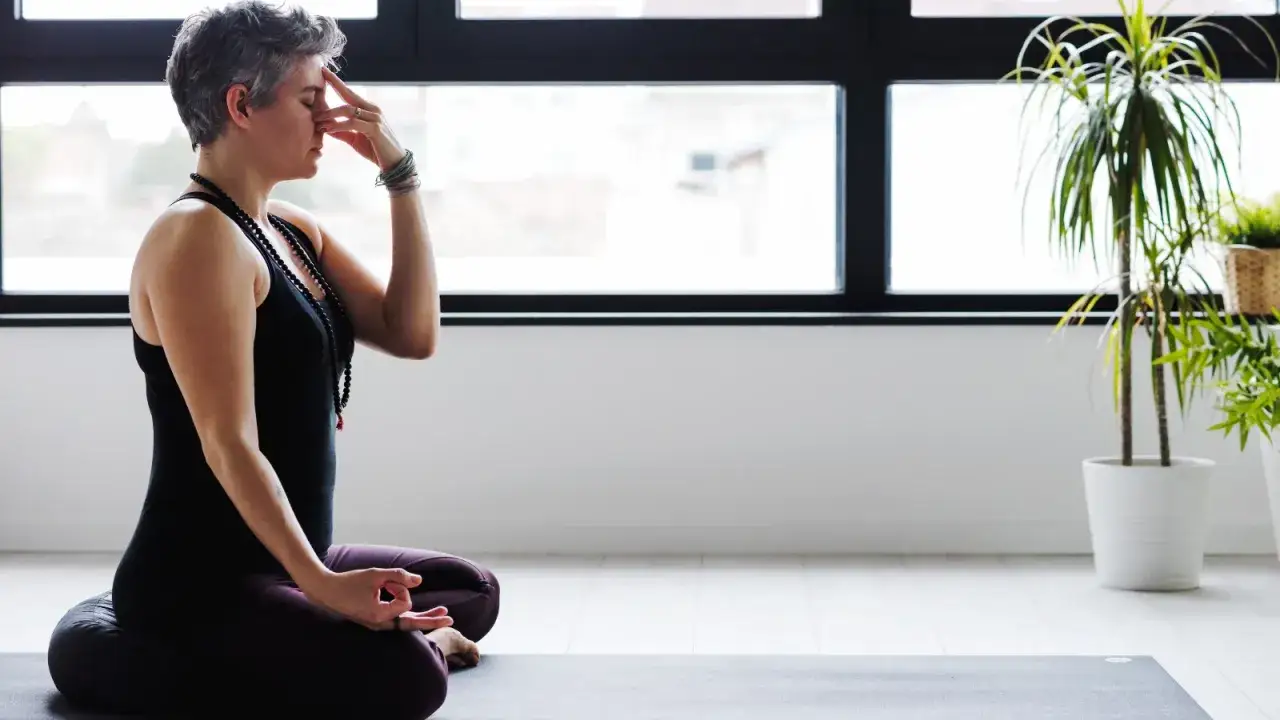 Frau in Meditationshaltung &uuml;bt Pranayama, um ihre Lungenfunktion zu verbessern.