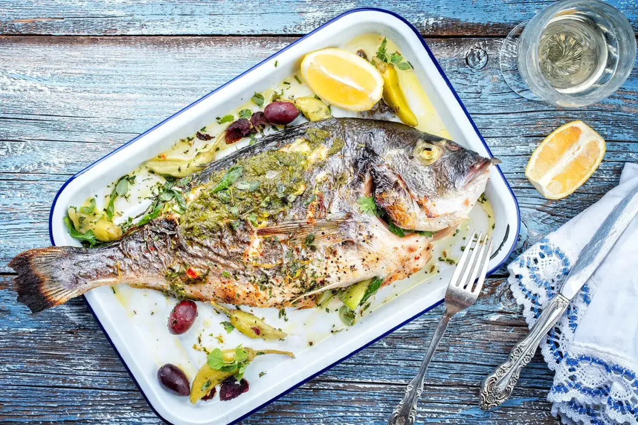 Dorade entière au barbecue, assaisonnée d'herbes et de citron. Le temps de cuisson est parfait pour un repas savoureux.