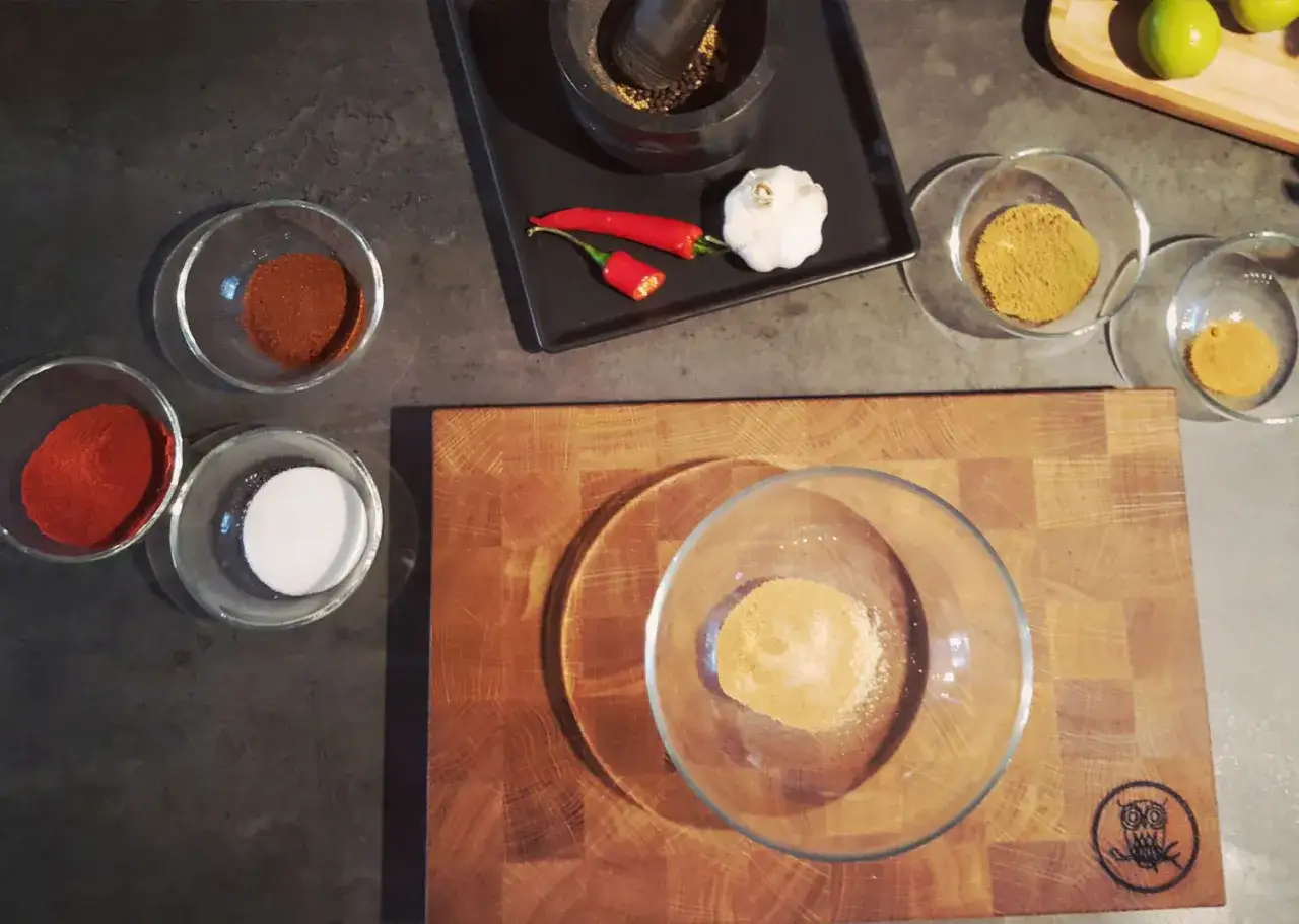 Förberedelser för ett fantastiskt bbq rub recept: chili, vitlök, peppar och kryddor i skålar.