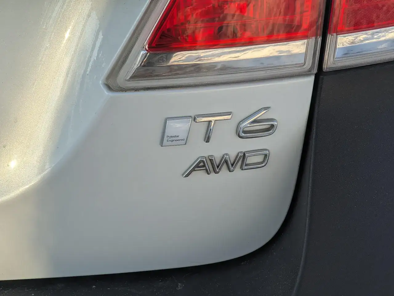 Emblematy T6 AWD i Polestar Engineered na białym samochodzie. Czy optymalizacja Polestar jest warta zachodu?