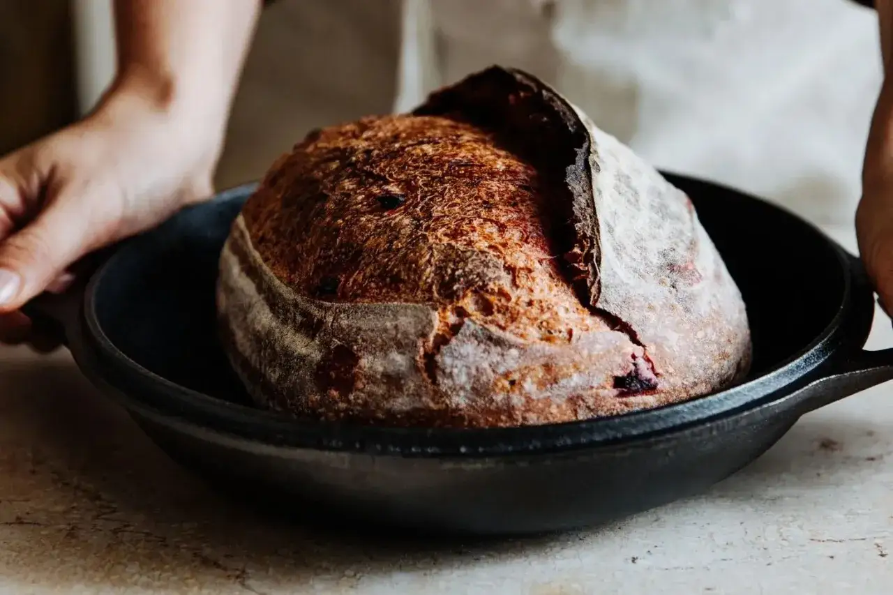 Frisch gebackenes Brot mit knuspriger Kruste in einer Gusseisenpfanne. Perfekt f&uuml;r das Brot backen mit Umluft oder Ober-/Unterhitze.