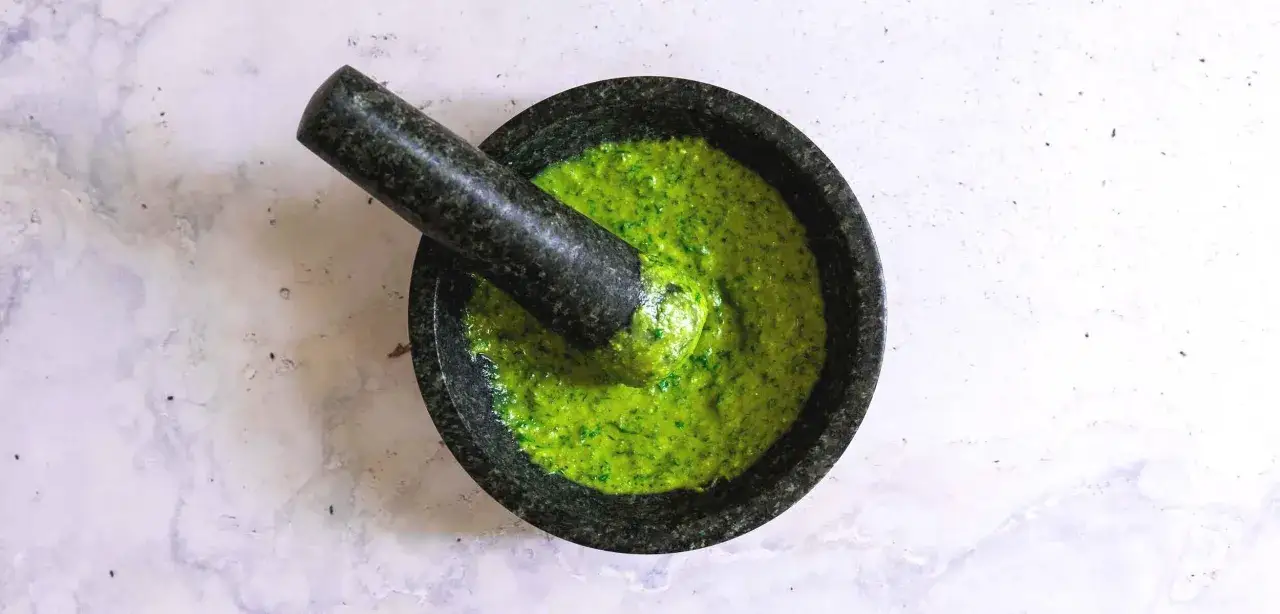 Frisches basilikum pesto in einem Mörser, bereit zum Verfeinern von Pasta oder Bruschetta.