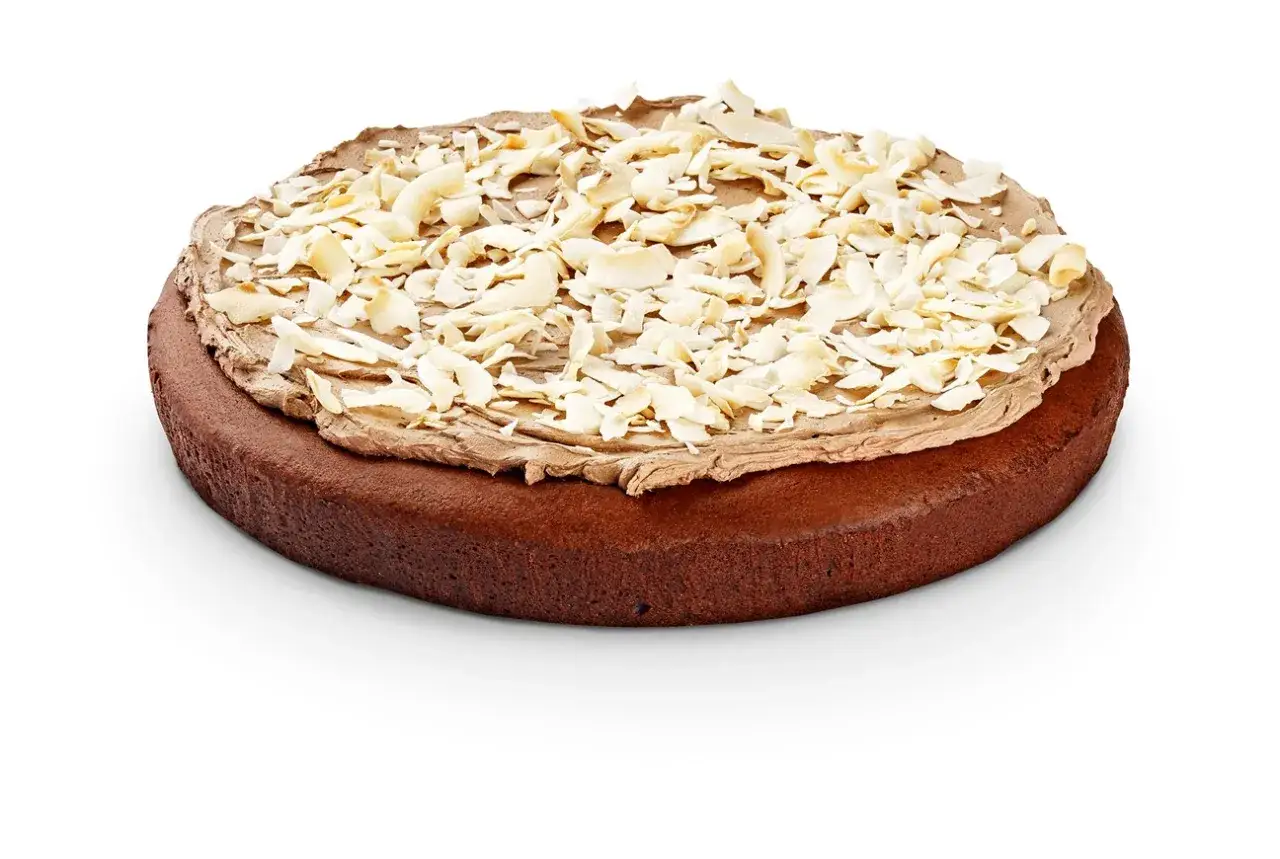 En läcker vegansk tårta med chokladbotten, chokladfrosting och toppad med kokoschips.