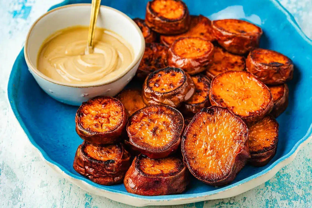 Tranches de patate douce r&ocirc;tie, caram&eacute;lis&eacute;es et servies avec une sauce cr&eacute;meuse. Une recette patate douce simple et d&eacute;licieuse.