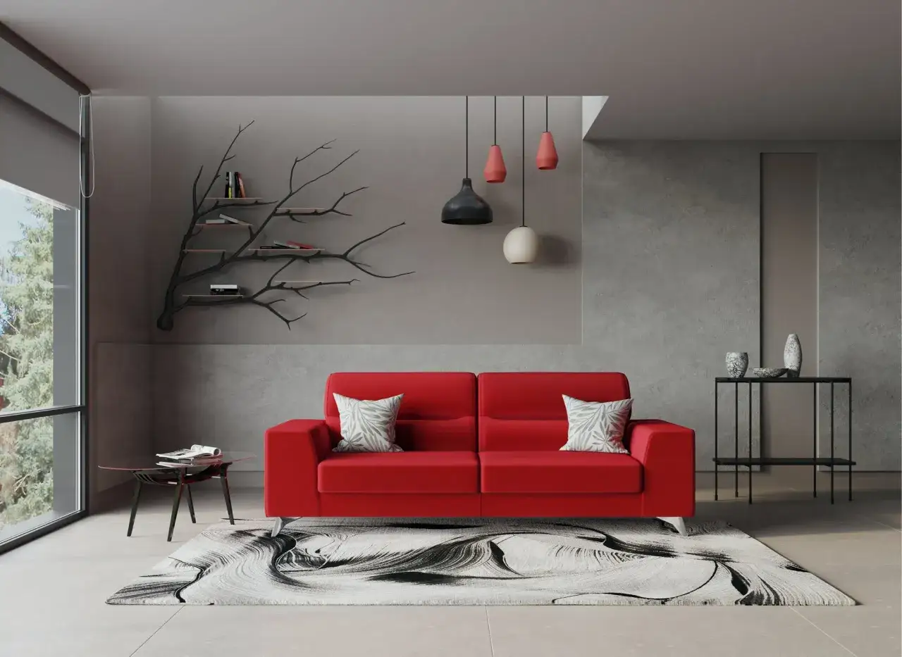 Un divano rosso acceso con due cuscini decorativi, un tappeto astratto e un tavolino di vetro. Ecco come disporre i cuscini sul divano per un tocco di stile.