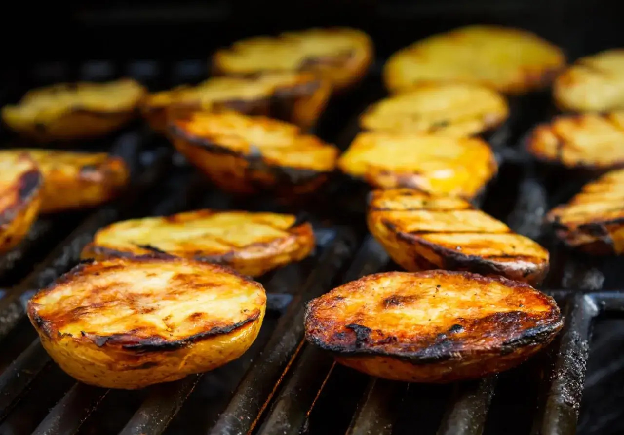 Patate alla griglia dorate e succulente, con segni di cottura perfetti, pronte per essere gustate.