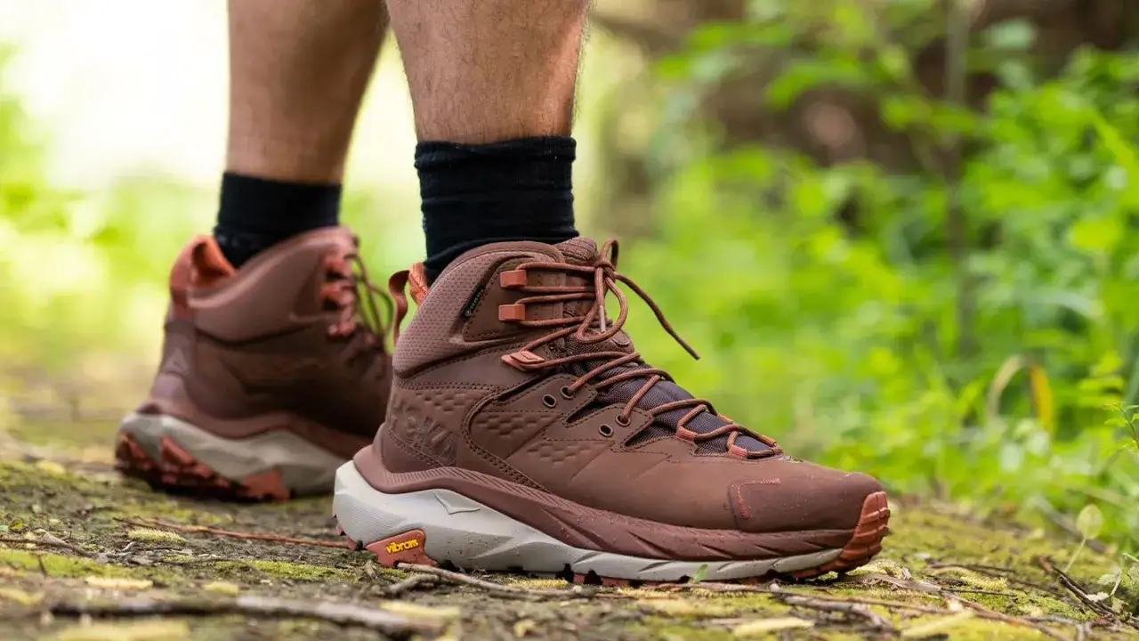 Brown hiking boots on a trail. Wondering how much do hiking boots weigh? These look lightweight for a trek.