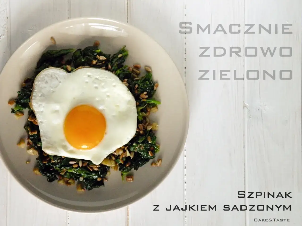Pyszny szpinak z jajkiem sadzonym i nasionami słonecznika na talerzu. Zdrowy i zielony posiłek.