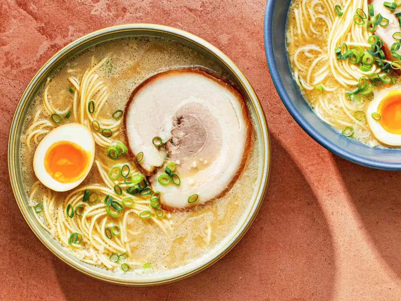 Dwie miski aromatycznego ramenu z makaronem, plastrem wieprzowiny, jajkiem i szczypiorkiem. Pyszny ramen kcal.