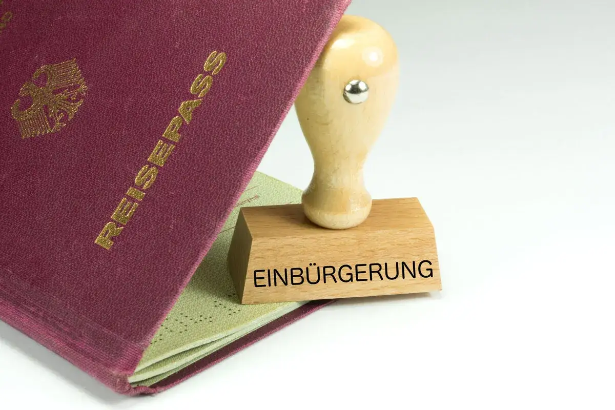 Ein Reisepass liegt offen, daneben ein Stempel mit dem Wort