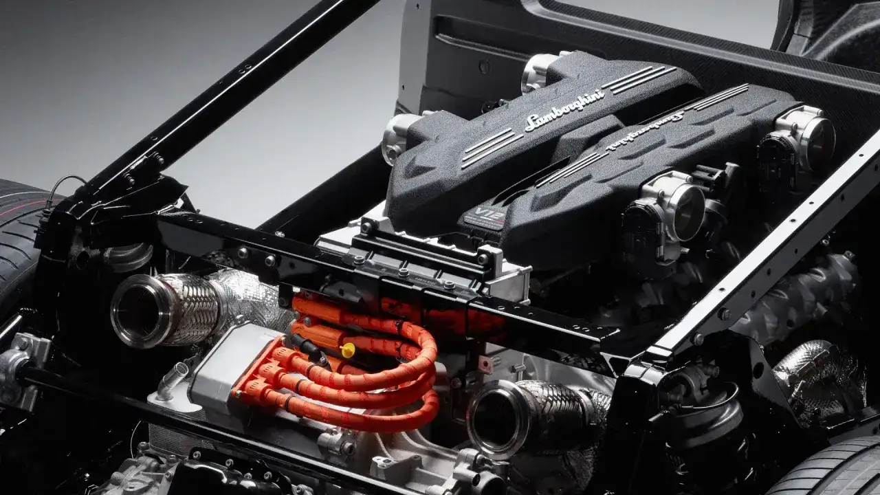 Silnik V12 Lamborghini Revuelto z pomarańczowymi kablami hybrydowymi.