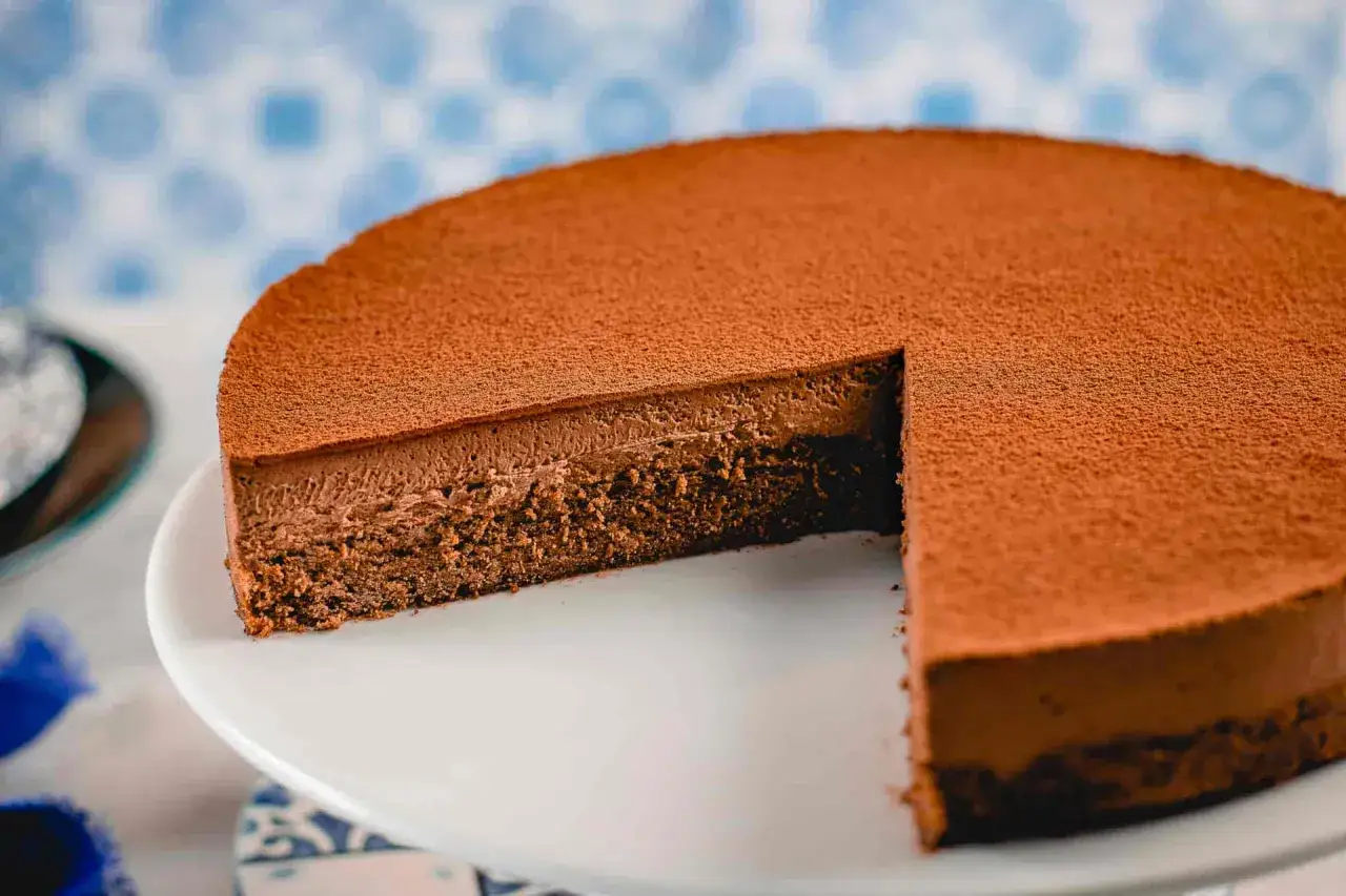 Una deliziosa torta Lisbona al cioccolato, con una soffice mousse e una base di pan di Spagna, spolverata di cacao.