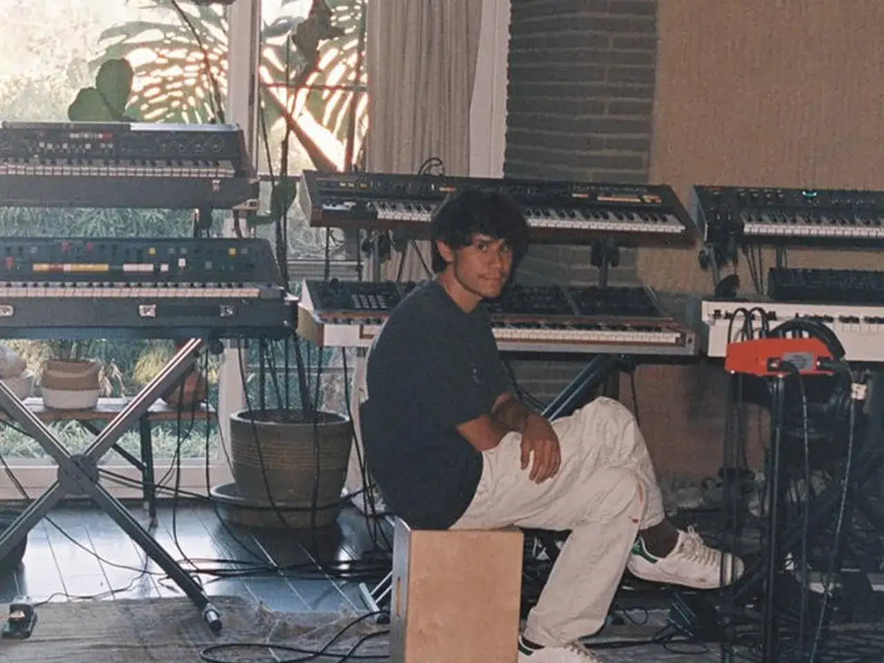 Frank Dukes w otoczeniu syntezator&oacute;w, tworząc muzykę w swoim studio.