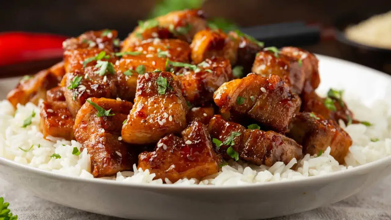 Carne guisada argui&ntilde;ano, jugosos trozos de carne glaseada con s&eacute;samo y perejil sobre una cama de arroz blanco.
