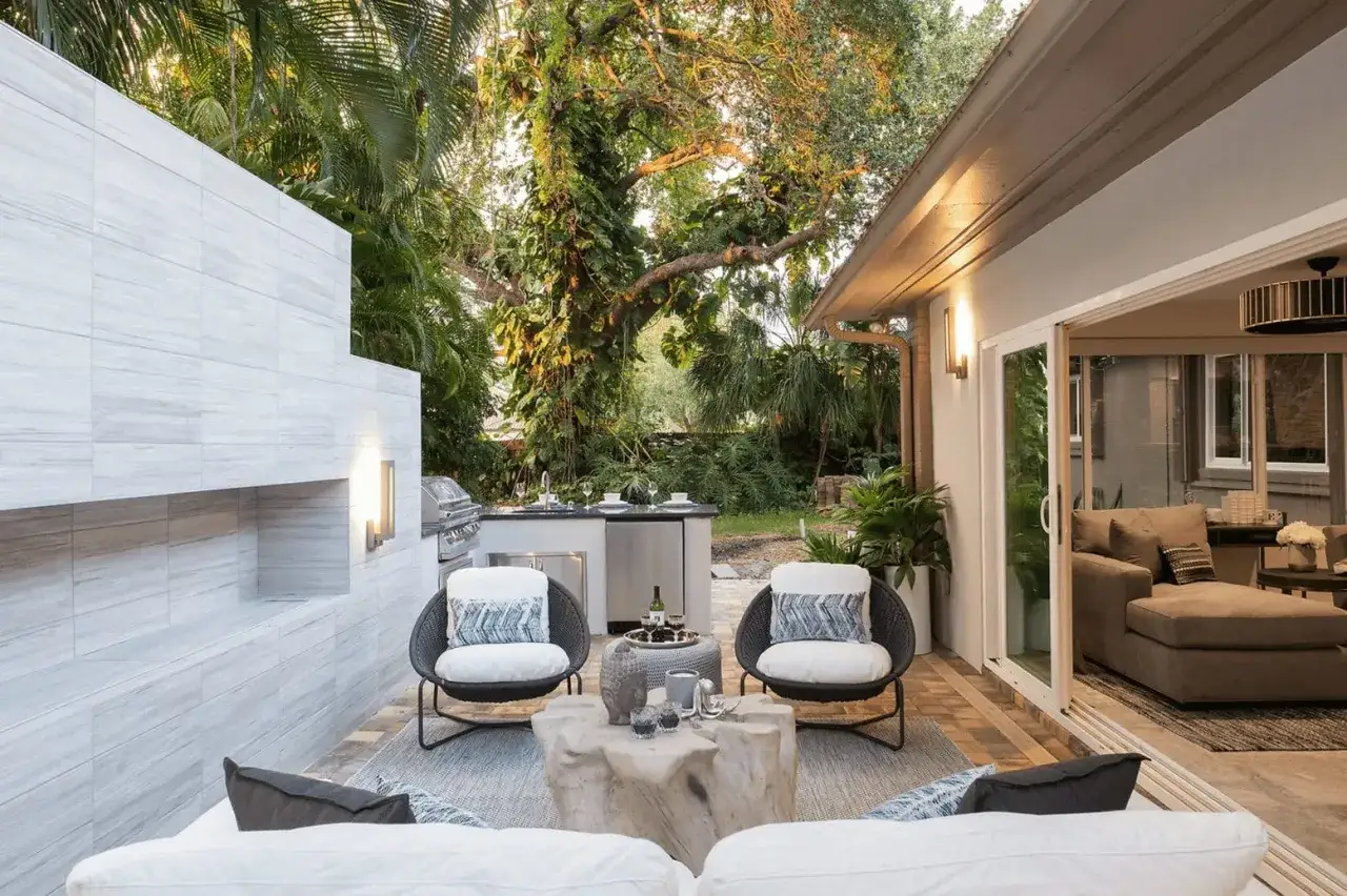 Un elegante spazio esterno con cucina e zona relax, ideale per chi cerca idee su come coprire un terrazzo scoperto e creare un'oasi accogliente.
