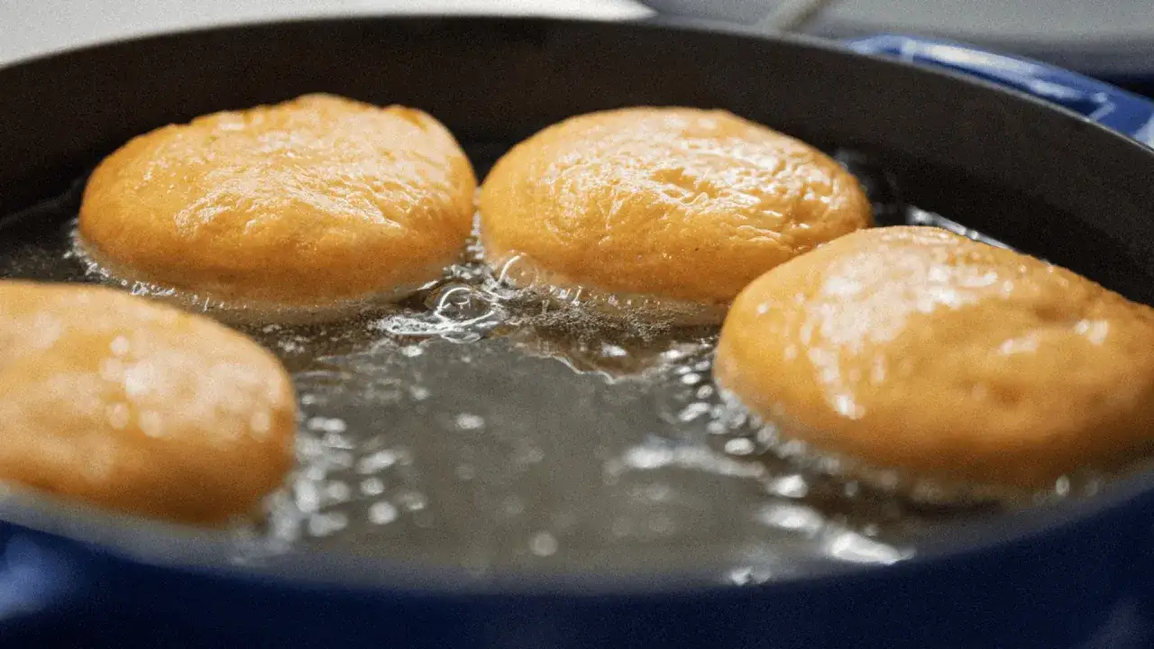 Pączki smażą się w gorącym tłuszczu. Idealna temperatura tłuszczu do smażenia pączków zapewnia im złocisty kolor i chrupkość.