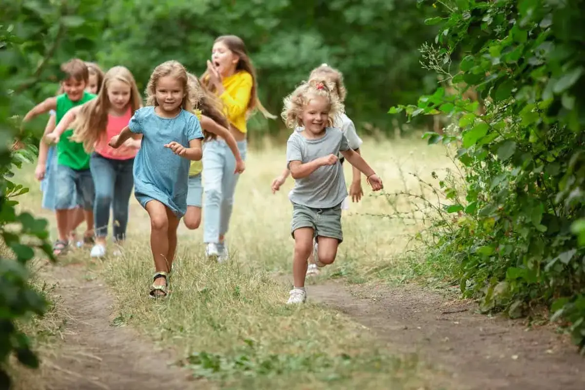 Fröhliches lauftraining kinder auf einem Waldweg. Kinder rennen lachend durch die Natur, voller Energie und Freude.