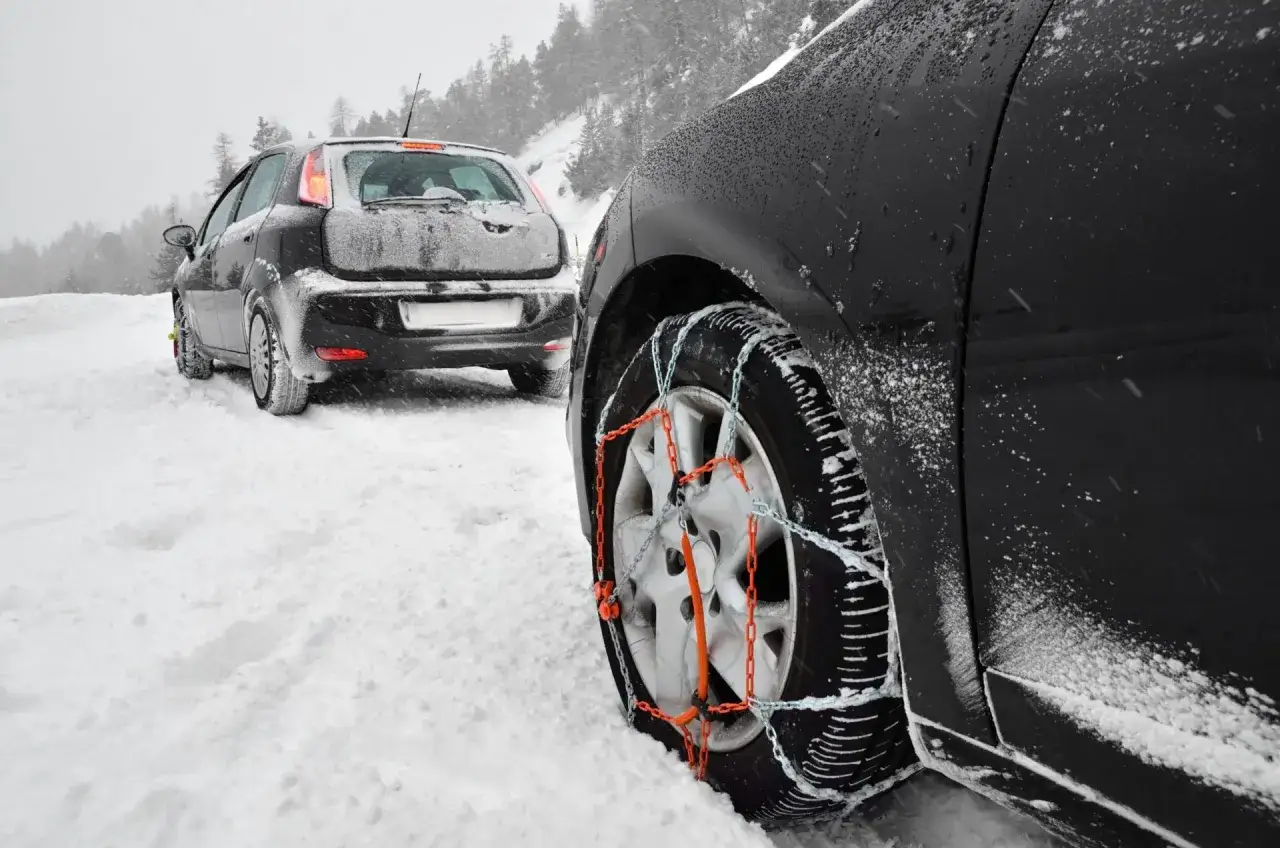 Coches con cadenas para la nieve en carreteras nevadas.