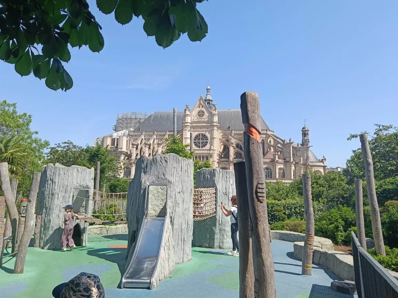 Plac zabaw z fantastycznymi atrakcjami dla małych dzieci, w tle piękna architektura.