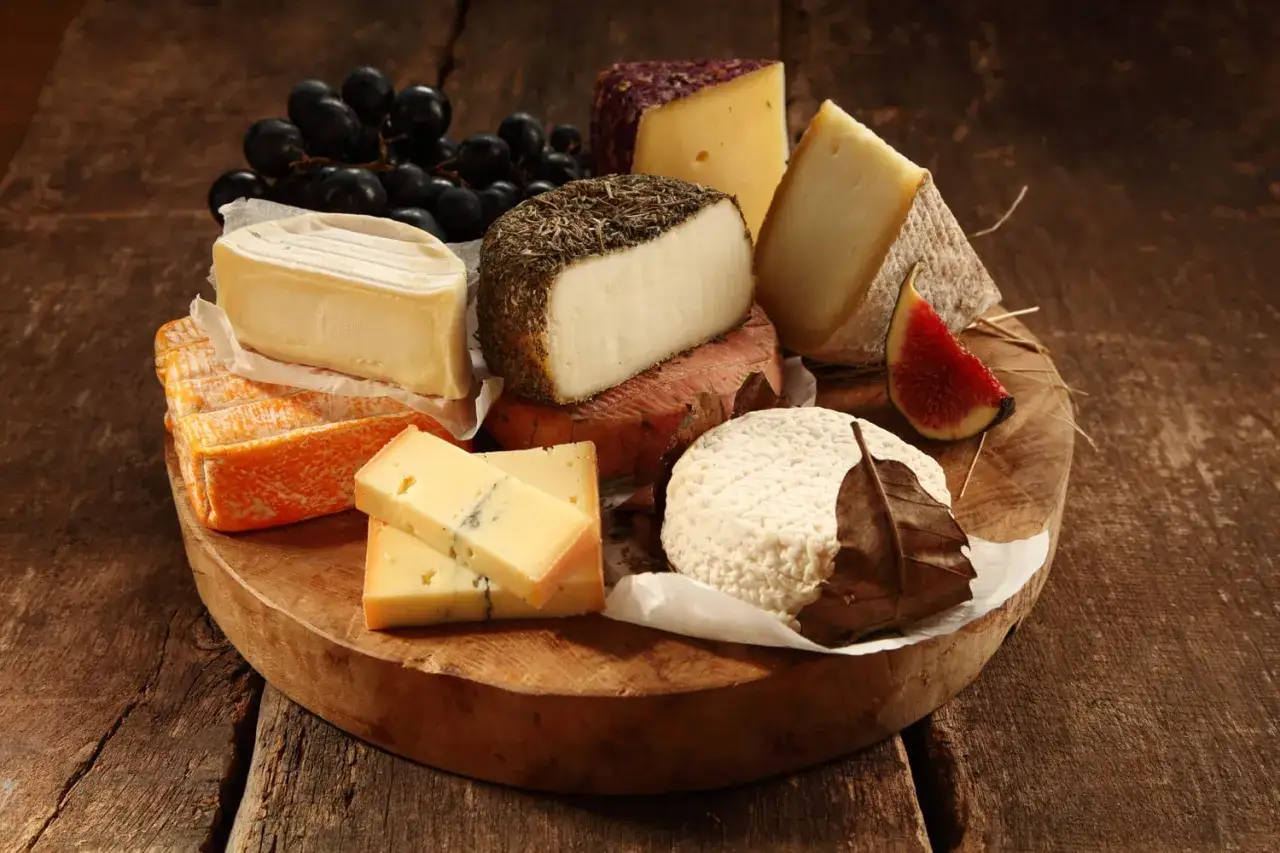 Plateau de fromages vari&eacute;s, une liste de fromages anglais, avec des raisins noirs et une figue.