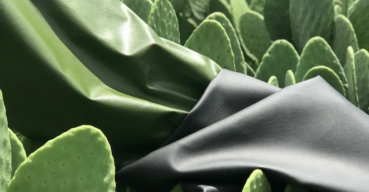 Deux drap&eacute;s de cuir v&eacute;g&eacute;tal, vert et noir, contrastent avec le fond de cactus verts.